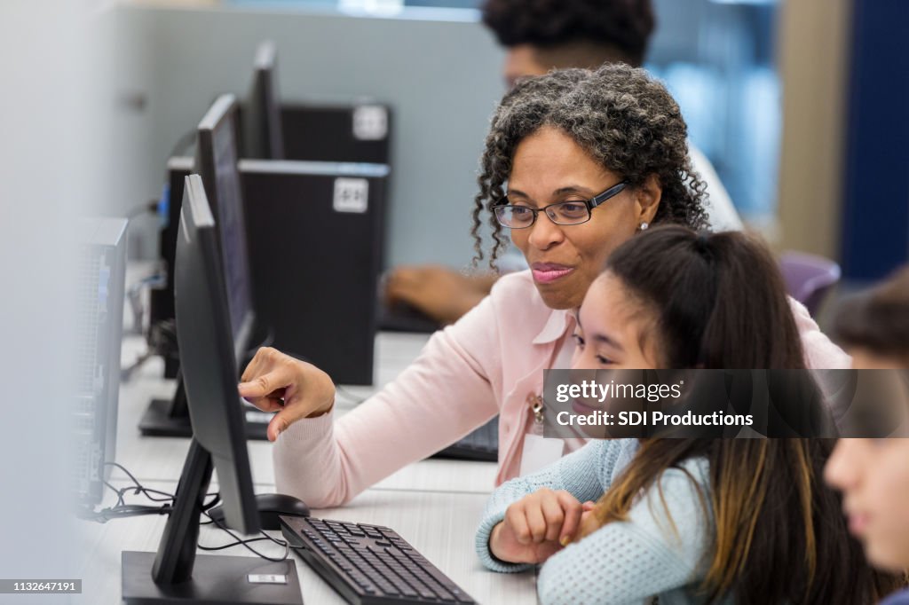 Lärare hjälper elever i datorlabb