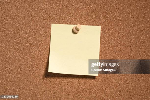 yellow colored note paper on cork board - bulletin board stock pictures, royalty-free photos & images