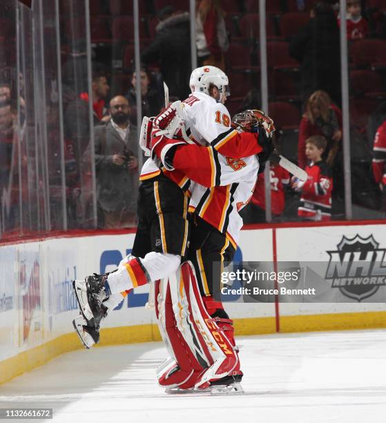 Matthew Tkachuk and David Rittich of the Calgary Flames celebrate their 2-1 victory over the New Jersey Devils at the Prudential Center on February...