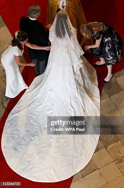 Catherine Middleton has her dress adjusted by her sister and Maid of Honor Pippa Middleton as she arrives with her father Michael Middleton before...