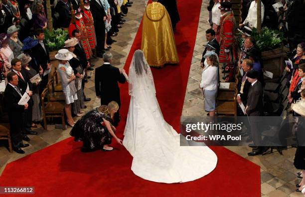 Woman adjusts the dress of Catherine Middleton as she arrives with her father Michael Middleton at Westminster Abbey on April 29, 2011 in London,...