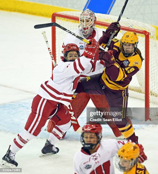 Center Abby Roque of the Wisconsin Badgers pushes center Kelly Pannek of the Minnesota Golden Gophers out of the crease in front of goalie Kristen...