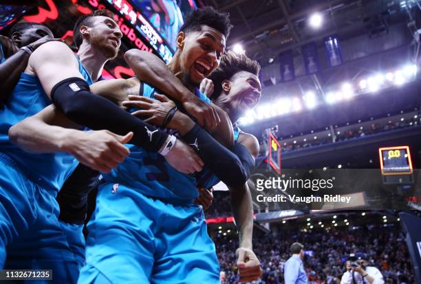 Jeremy Lamb of the Charlotte Hornets celebrates with teammates after sinking a buzzer beater to win an NBA game against the Toronto Raptors at...