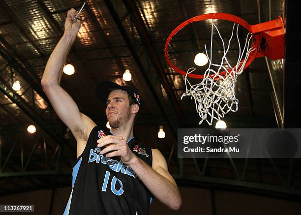 Tom Abercrombie of the Breakers cuts the net down after winning game three of the NBL Grand Final series between the New Zealand Breakers and the...