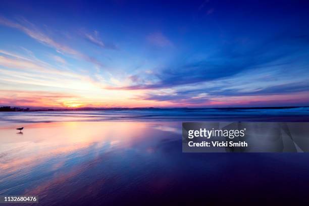 beautiful yellow and blue sky sunrise over the ocean - dusk sky stock-fotos und bilder