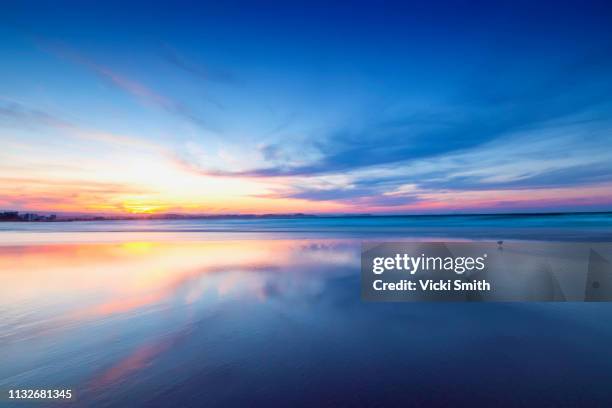 beautiful yellow and blue sky sunrise over the ocean - horizont über wasser stock-fotos und bilder