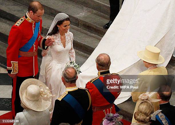 Prince William holds the hand of his bride Catherine Middleton, now to be known as Catherine, Duchess of Cambridge, as they walk down the aisle and...