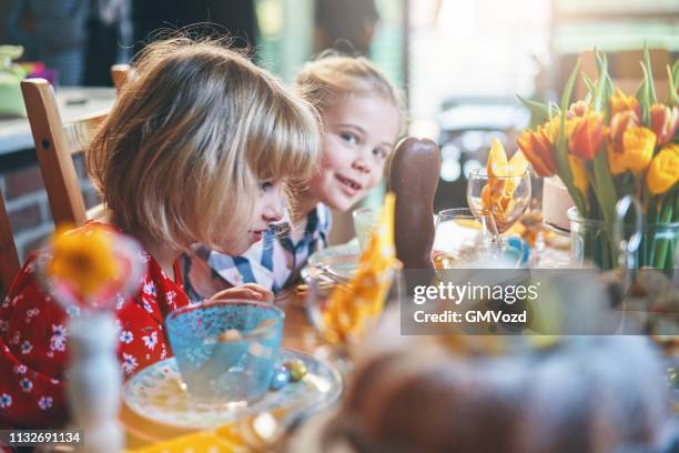 cute little kids having fun on a decorated easter table - easter family stock pictures, royalty-free photos & images