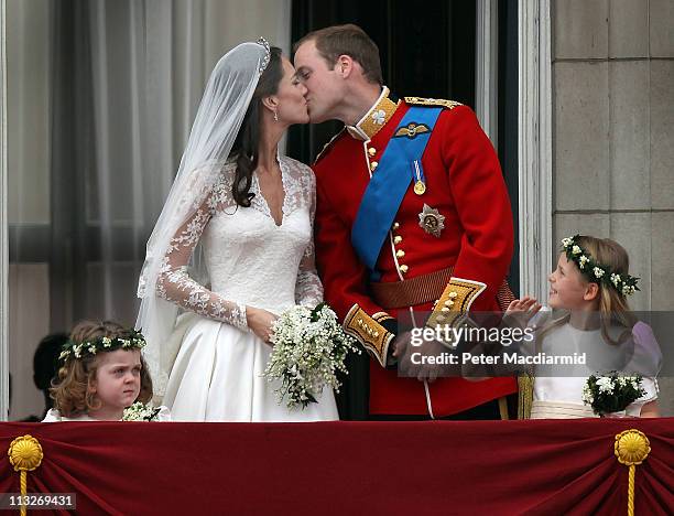 Prince William, Duke of Cambridge and Catherine, Duchess of Cambridge kiss as Bridesmaids Grace Van Cutsem and Margarita Armstrong-Jones look on from...