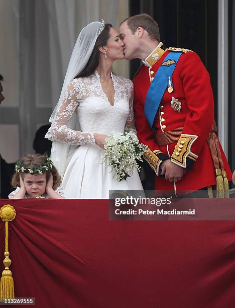 Prince William, Duke of Cambridge and Catherine, Duchess of Cambridge kiss as Bridesmaid Grace Van Cutsem looks at the crowd from the balcony at...