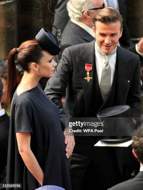 David Beckham pats the tummy of his pregnant wife Victoria Beckham as they attend the Royal Wedding of Prince William to Catherine Middleton at...