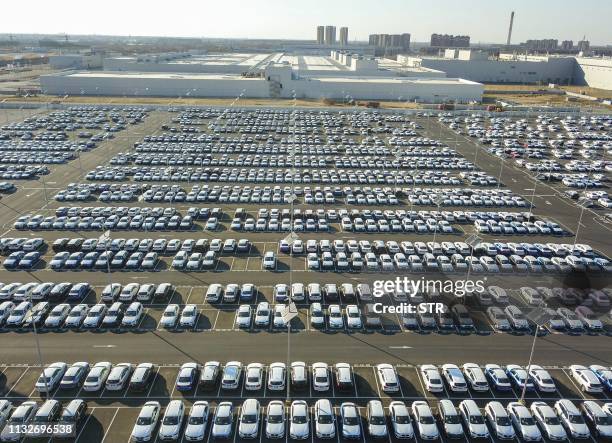 This aerial photo taken on March 23, 2019 shows new BMW cars lined up at a BMW factory in Shenyang in China's northeastern Liaoning province. / China...