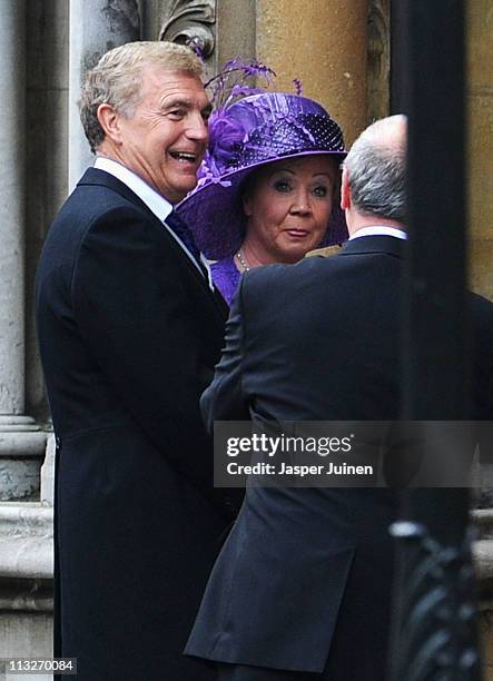 Sir Trevor Brooking walks as Prince William and Princess Catherine make the journey by carriage procession to Buckingham Palace following their...