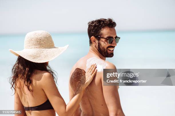 she loves his skin - couple on beach sunglasses stock pictures, royalty-free photos & images