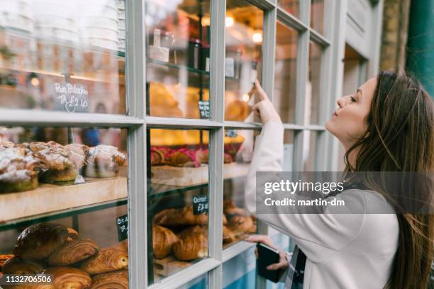 hungrige frau in der bäckerei - breakfast to go stock-fotos und bilder