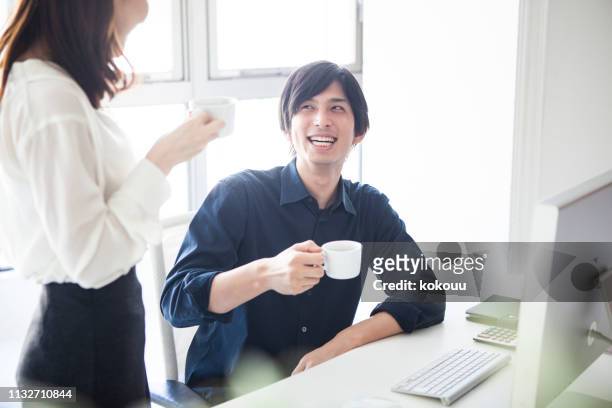 manager and designer chatting while drinking coffee - office coffee break stock pictures, royalty-free photos & images
