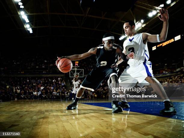 basketball player being guarded by defender - dribbling sports - fotografias e filmes do acervo