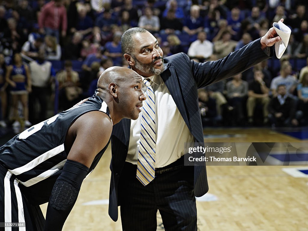 Basketball coach giving directions to player