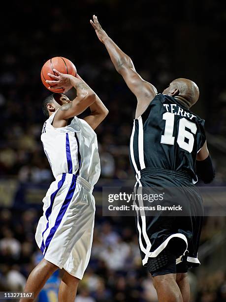 basketball player shooting ball over defender - basketball player stock pictures, royalty-free photos & images