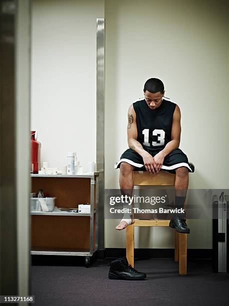 injured basketball player sitting in training room - sports training clinic fotografías e imágenes de stock