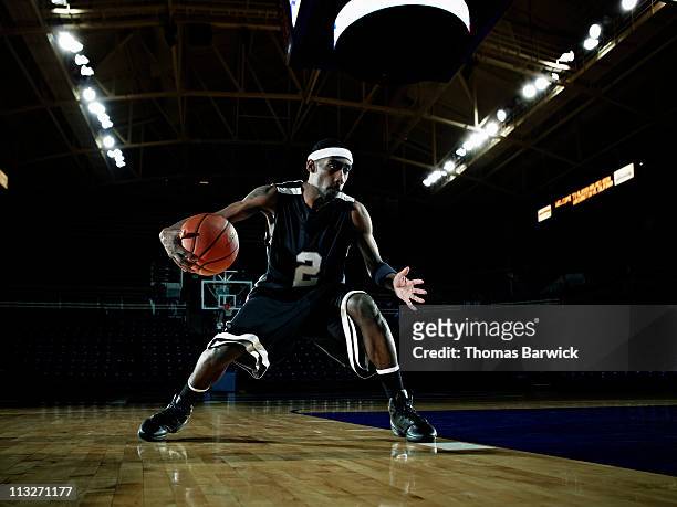 basketball player dribbling basketball on court - professional sportsperson stock pictures, royalty-free photos & images