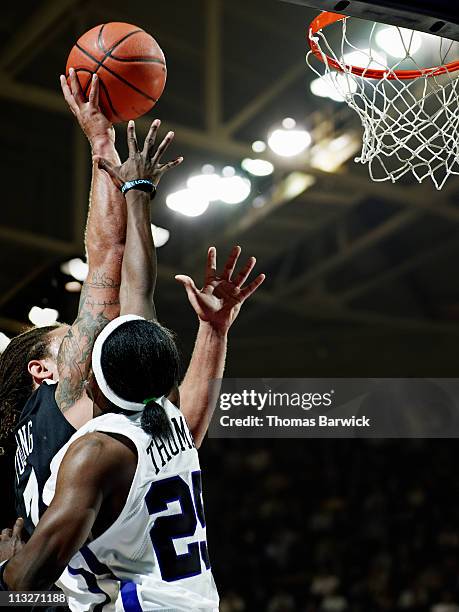 basketball player dunking the ball over defender - shooting baskets stockfoto's en -beelden