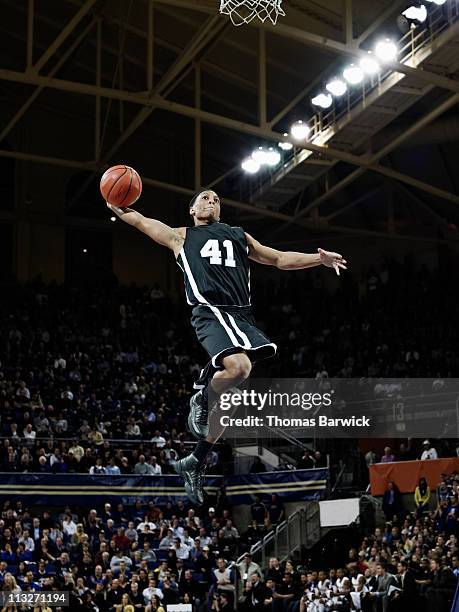 basketball player preparing to dunk ball in arena - mate de baloncesto fotografías e imágenes de stock