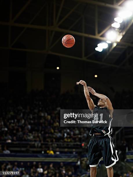 basketball player shooting jump shot in arena - hitting foto e immagini stock