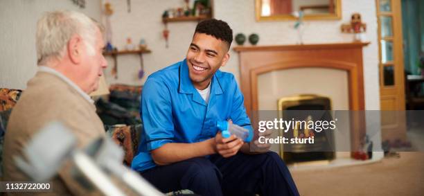 friendly male care nurse - home carer stock pictures, royalty-free photos & images