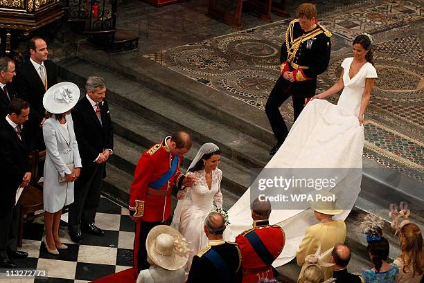 Prince William, Duke of Cambridge bows and Catherine, Duchess of Cambridge curtsies in front of Queen Elizabeth II as they leave Westminster Abbey...