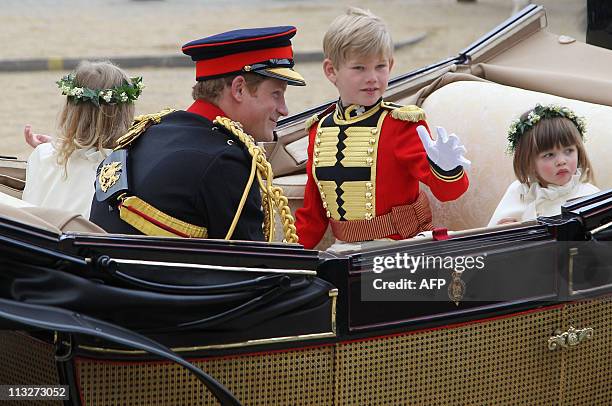 Britain's Prince Harry, page boy Tom Pettifer and bridesmaid Eliza Lopes make the journey by carriage procession to Buckingham Palace following the...