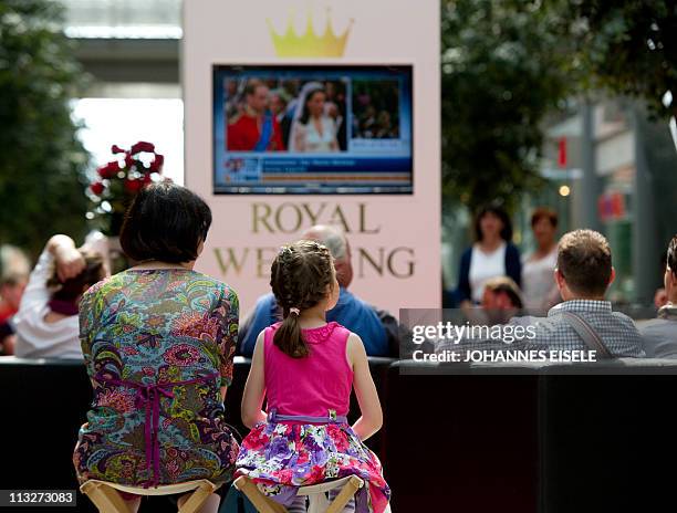 People attend the public viewing of the royal wedding of the royal wedding of Britain's Prince William and Kate Middleton in a shopping mall in...