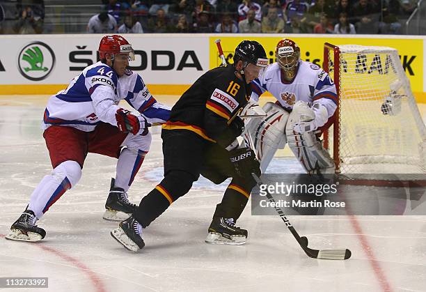 Michael Wolf of Germany and Nikolai Belov of Russia battle for the puck during the IIHF World Championship group A match between Germany and Russia...