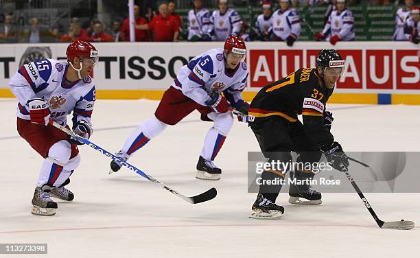 Patrick Reimer of Germany and Alexei Kaigorodov of Russia battle for the puck during the IIHF World Championship group A match between Germany and...