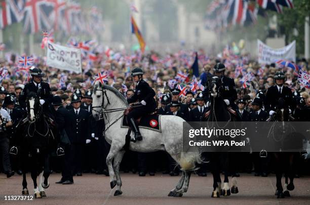 Mounted police control the crowd as they walk along the Processional Route to Buckingham Palace to celebrate the Royal Wedding of Prince William,...