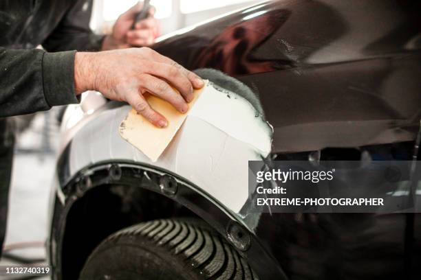 reparera en olycka-skadade bil del med hjälp av en bil filler - sandpapper bildbanksfoton och bilder