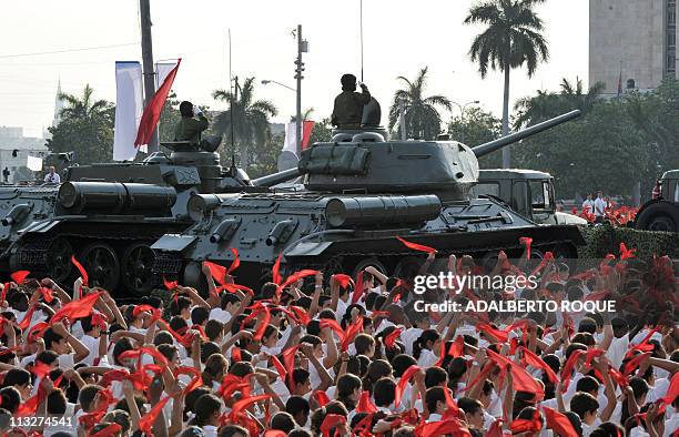 Cuban pioneers wave their kerchiefs simulating waves, on April 16 around the vintage URSS-made T-34/85 tank and the SU-100 self-propelled-gun used by...