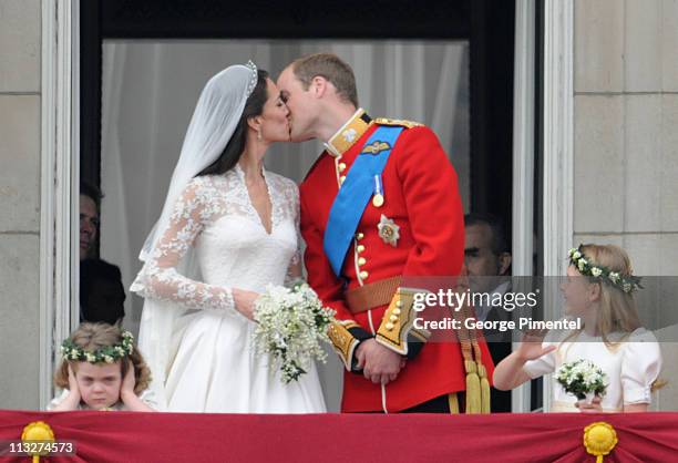 Prince William, Duke of Cambridge and Catherine, Duchess of Cambridge kiss next to Grace Van Cutsem and Margarita Armstrong-Jones on the balcony at...