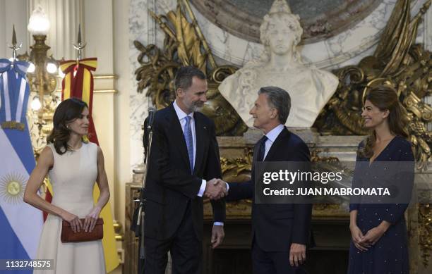 Spain's King Felipe VI and Argentina's President Mauricio Macri shake hands as Queen Letizia and Argentine First Lady Juliana Awada look on during...