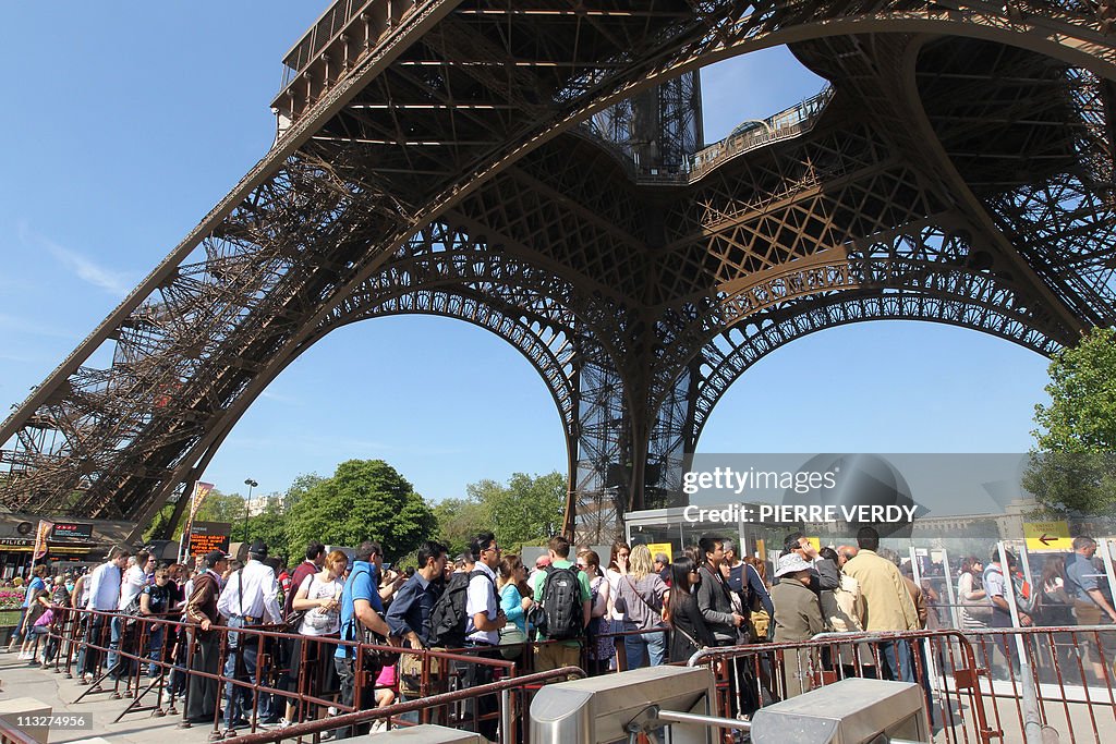 Tourists queue outside the Eiffel Tower