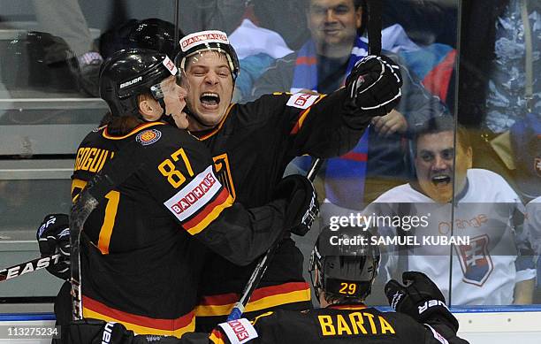 Germany's Patrick Reimer celebrates after scoring, with his teammates Philip Gogula and Alexander Barta, during the IIHF Ice Hockey World...