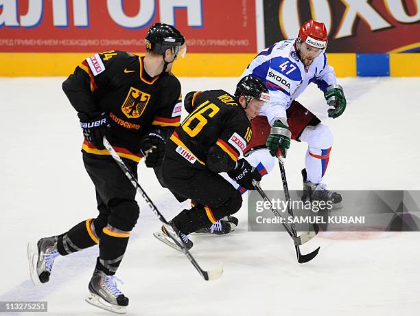 Germany's Michael Wolf and Andre Rankel vie for the puck with Russia's Alexander Radulov during the IIHF Ice Hockey World Championship group A match...