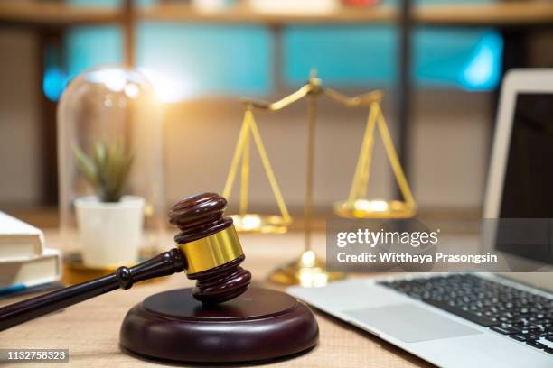 justice and law concept.lawyer workplace with laptop and documents with dark wooden - lawsuit stock pictures, royalty-free photos & images