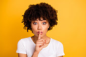 Close-up portrait of her she nice cute lovely attractive charming cheerful wavy-haired lady showing shh symbol isolated on bright vivid shine yellow background