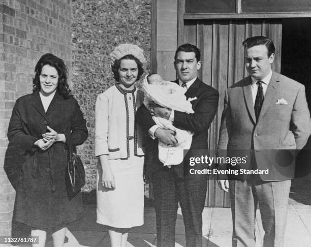 British criminal and gangster Ronald 'Ronnie' Kray holding a baby with two unidentified woman and an unidentified man, UK, 22nd May 1969.