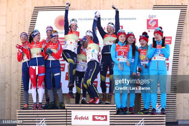 Norways Heidi Weng, Ingvild Flugstad Oestberg, Astrid Unrenholdt and Therese Johaug celebrate their silver medals, Swedens Ebba Andersson, Frida...