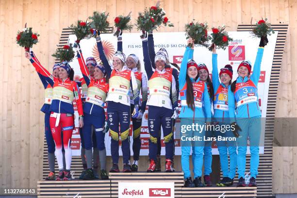 Norways Heidi Weng, Ingvild Flugstad Oestberg, Astrid Unrenholdt and Therese Johaug celebrate their silver medals, Swedens Ebba Andersson, Frida...