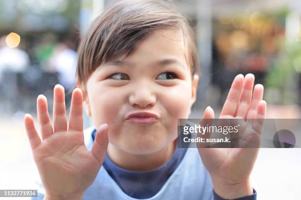 portrait of playful girl looking through window with funny face - kid looking through window stock pictures, royalty-free photos & images
