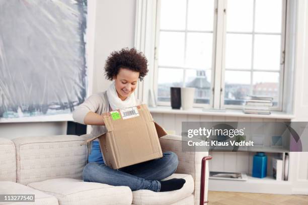 young woman opening package - open collar fotografías e imágenes de stock