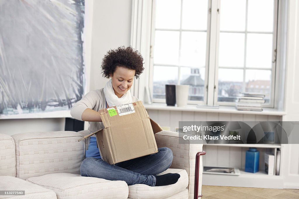 Young woman opening package